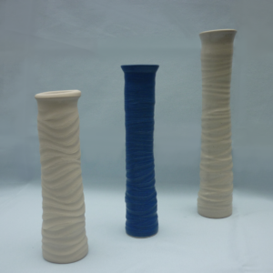 Drei schmale hohe Vasen in einer Reihe